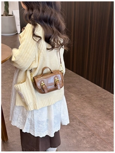 Girl wearing a dark brown vintage oil wax leather crossbody bag with dual buckles