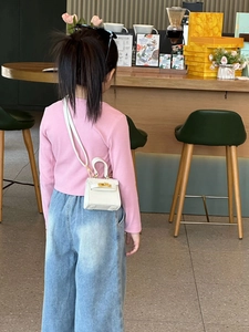 Vue détaillée du mini sac bandoulière blanc pour enfants avec fermoir doré et poignée