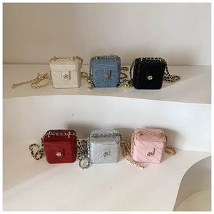 Macro view of multi-color quilted mini box bags with camellia flower twist locks