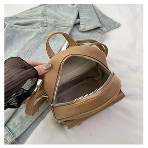 Detailed interior of a mini khaki leather backpack showing grey herringbone lining