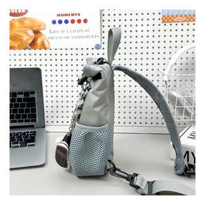 Detail of grey-blue nylon chest bag featuring side mesh pocket and buckle closure