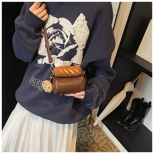 Détail du sac cylindrique marron avec décor pain en peluche et breloque biscuit sur modèle