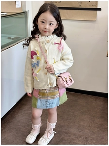 Detail of pink vintage oil wax leather mini crossbody bag on a child's knit outfit