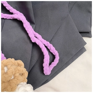 Detail view of purple crochet shoulder strap and 3D floral accents for kids bag