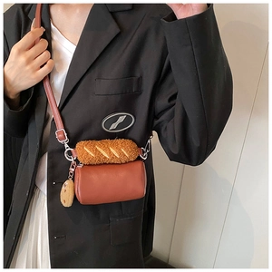 Mini sac cylindrique marron avec détail de poignée baguette en peluche sur modèle