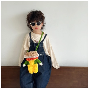 Detail of handmade crochet cartoon doll crossbody bag with vibrant yellow and green yarn