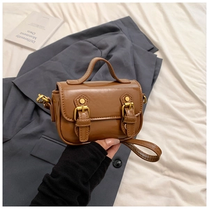 Detailed view of caramel oil-waxed PU leather mini crossbody bag with vintage gold buckles