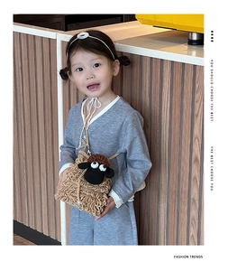 Detail of child wearing a brown crochet sheep shoulder bag with textured curly yarn