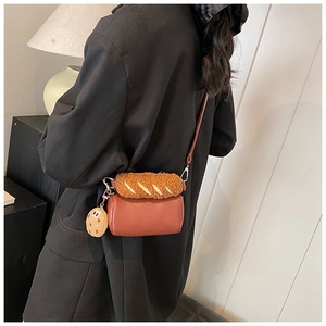 Détail d'un sac cylindrique en cuir marron avec un couvercle créatif en peluche en forme de pain