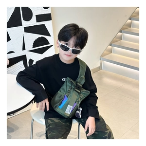Detail of army green nylon crossbody bag with adjustable buckle and mesh pocket for kids
