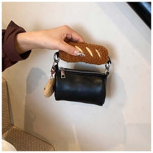 Gros plan du sac cylindre noir avec poignée en peluche pain et breloque biscuit