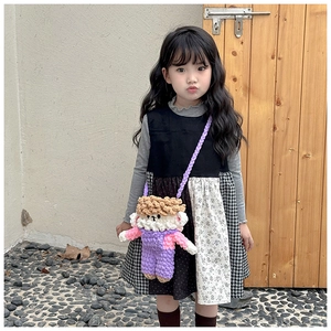 Close-up of handmade crochet cartoon doll crossbody bag with knitted shoulder strap