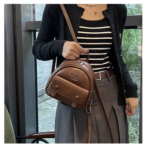 Detail of vintage brown faux leather mini backpack with adjustable strap and fashion logo