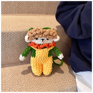 Detail of a handmade crochet cartoon doll bag with a yellow jumpsuit and green top