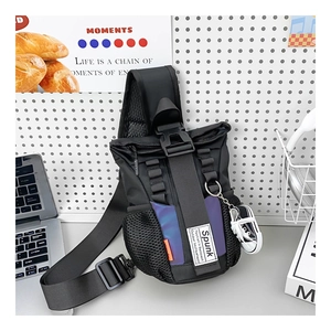 Close-up of black tactical kids chest bag with purple reflective panel and sneaker charm