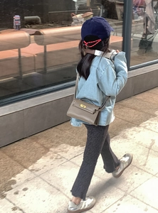 Détail d'un mini sac bandoulière vintage en cuir marron avec boucle dorée pour enfant