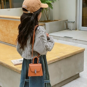 Mini orange-brown crossbody bag for kids with top handle and metal buckle closure