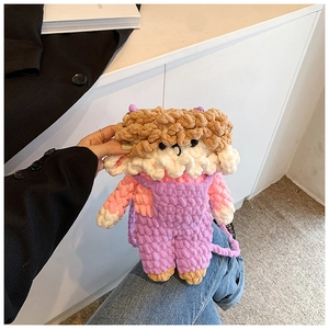 Close-up of handmade crochet cartoon sheep crossbody bag with purple overalls and texture