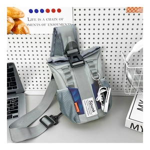 Detail view of grey nylon chest bag with colorful accents and mini sneaker charm