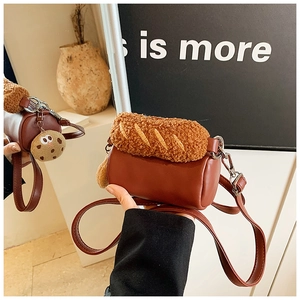 Détail d'un sac cylindrique marron avec décor pain en peluche et pendentif biscuit mignon