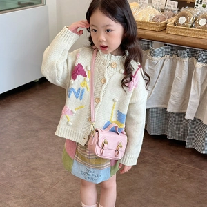 Girl's vintage oil wax leather mini handbag and knit cardigan in a bakery setting