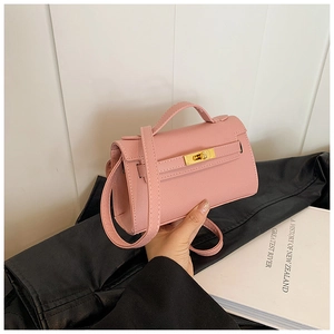 Détail du mini sac à main rose avec texture cuir litchi et fermoir rotatif doré