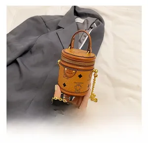 Mini braune Beuteltasche mit Bärenprint und Goldkette von einer Person gehalten