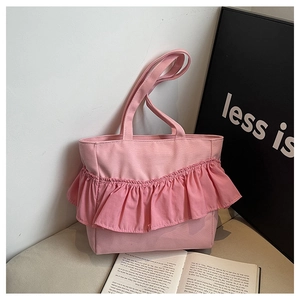Detail of pink canvas tote bag featuring layered ruffle pleats and dual shoulder straps