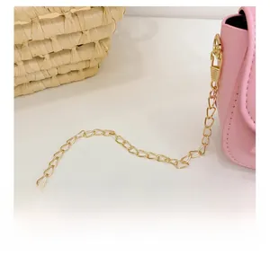 Detailed close-up of pink leather handbag featuring a glossy golden metal chain strap