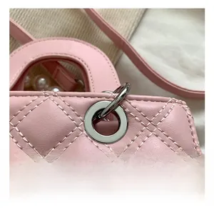 Detail of pink quilted handbag with pearl handle and polished silver hardware