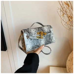 Détail du sac à main à motif serpent avec fermoir doré et poignée pour enfants