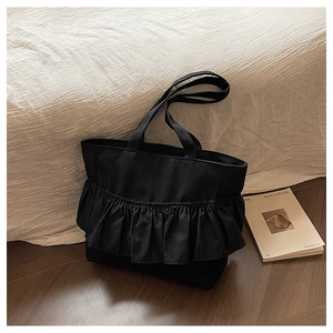 Detail of black canvas tote bag showing the ruffled pleated texture and spacious design