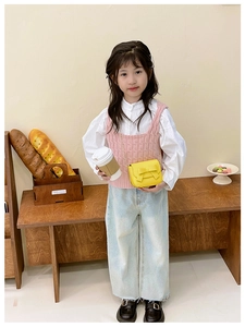 Girl in pink knit vest carrying a yellow mini crossbody bag with a cute bow detail