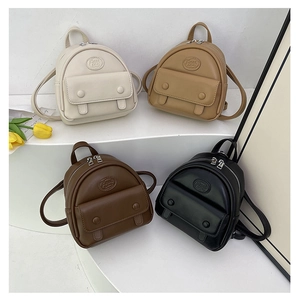Detailed arrangement of mini synthetic leather backpacks in four colors on a white display