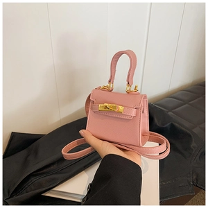 Gros plan détaillé du micro sac rose avec fermoir doré et texture de cuir croisé