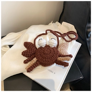Close-up of handmade crochet crab bag showing detailed knit texture and woven strap