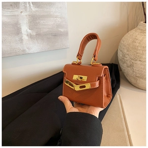 Détail d'un mini sac à main caramel avec fermoir rotatif métallique et sangle croisée