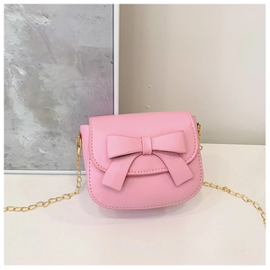Detailed view of the pink girls crossbody bag featuring a large bow and gold chain strap
