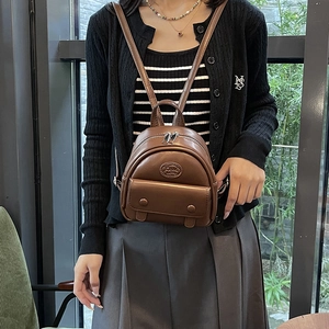 Minimalist deep brown leather mini backpack for women featuring vintage front pockets