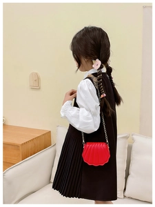 Détail du mini sac bandoulière rouge en forme de coquillage avec chaîne dorée