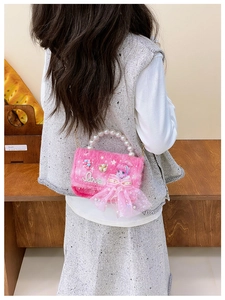 Detail der rosa Plüsch-Handtasche für Mädchen mit Perlengriff und Puppendekor