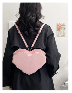 Vue détaillée du mini sac à dos rose en forme de cœur avec motif toile d'araignée