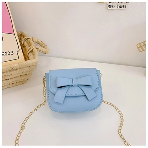 Close-up of light blue mini crossbody bag featuring a cute bow and gold chain strap