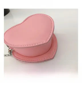 Détail du sac rose en forme de cœur montrant le cuir PU grainé et la chaîne en argent