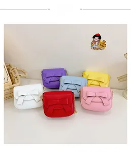 Group display of colorful mini girls' crossbody bags with bow detail and chain straps