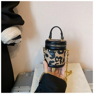 Detailansicht einer Mini-Beuteltasche mit Leopardenmuster, Goldkette und schwarzem Leder