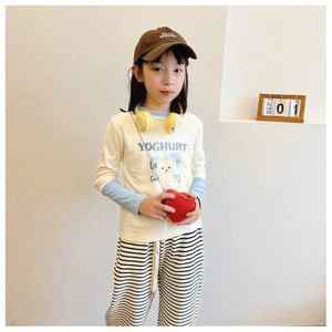 Gros plan sur le sac en forme de cœur et le pantalon rayé pour tenue d'enfant chic