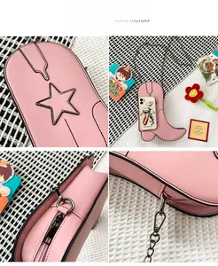 Detail view of pink boot-shaped crossbody bag with star stitching and metal chain strap