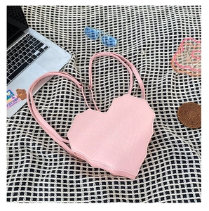 Sac rose en forme de cœur avec coutures en toile d'araignée blanche sur carreaux