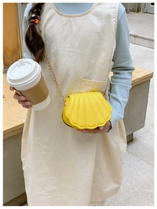 Détail du mini sac jaune en forme de coquille avec cuir plissé et chaîne dorée
